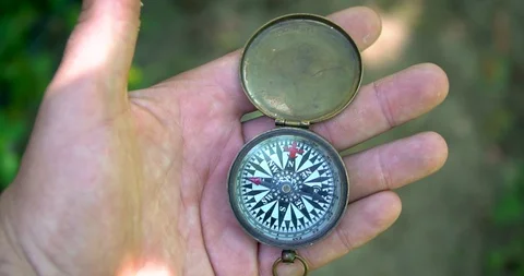 Man holding an old compass in hand and rotate around the axis. Stock Footage 127747371