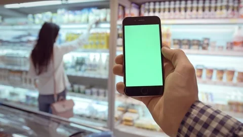 Man holding with one hand his mobile phone with green screen. Sliding his finger Stock Footage 276560851