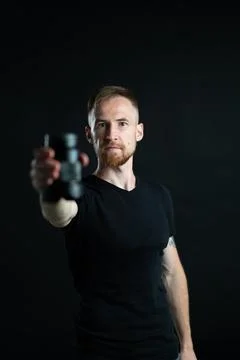 A man holding optics for a camera in a studio Stock Photos