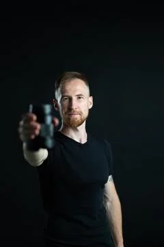 A man holding optics for a camera in a studio Stock-Fotos