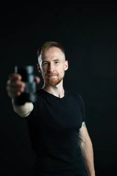 A man holding optics for a camera in a studio 스톡 사진