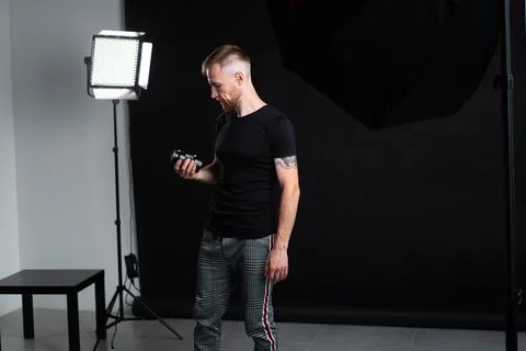 A man holding optics for a camera in a studio Stock Photos