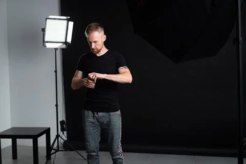 A man holding optics for a camera in a studio Stock Photos
