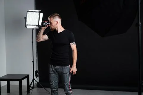 A man holding optics for a camera in a studio 写真素材