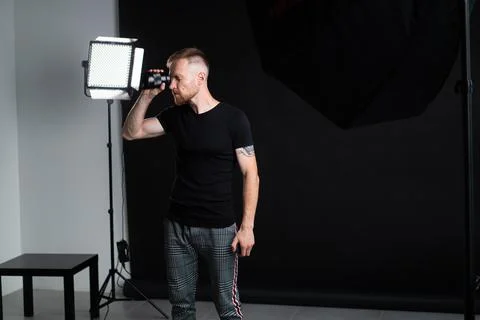 A man holding optics for a camera in a studio Photos
