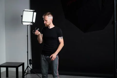A man holding optics for a camera in a studio Photos