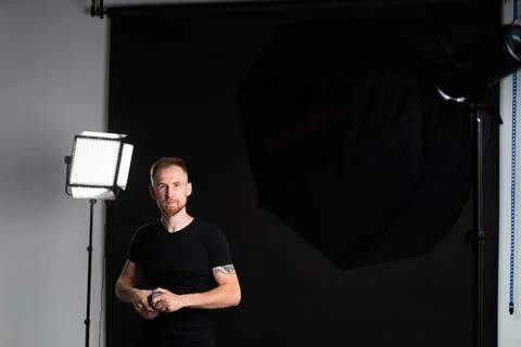 A man holding optics for a camera in a studio 스톡 사진