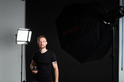 A man holding optics for a camera in a studio Stock-Fotos