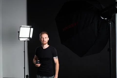 A man holding optics for a camera in a studio Photos