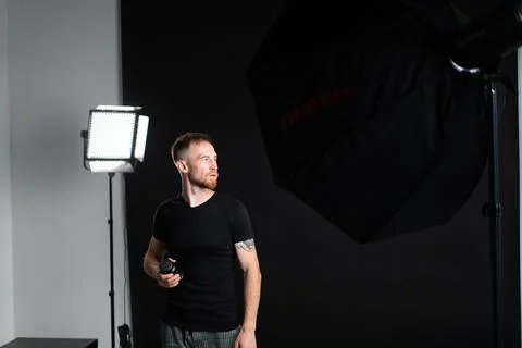 A man holding optics for a camera in a studio Stockfoto's