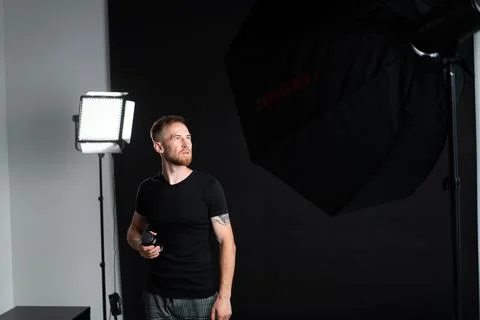 A man holding optics for a camera in a studio 스톡 사진