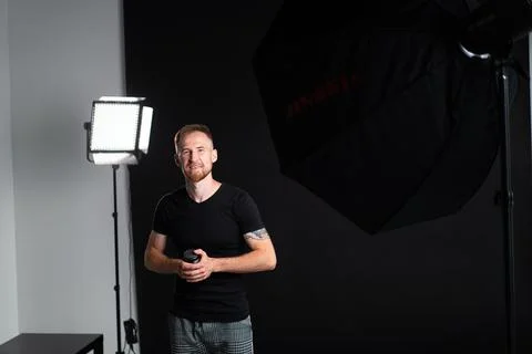 A man holding optics for a camera in a studio 스톡 사진
