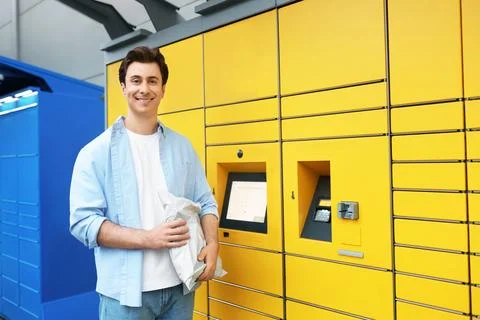 Man holding a package picked up from an automated parcel locker. Convenient.. Stock Photos