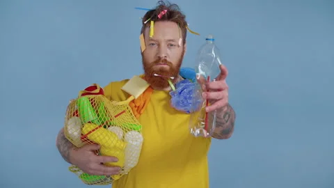 Man holding  package with plastic garbage and squeezing a bottle. Slowmotion. Stock Footage 147179936