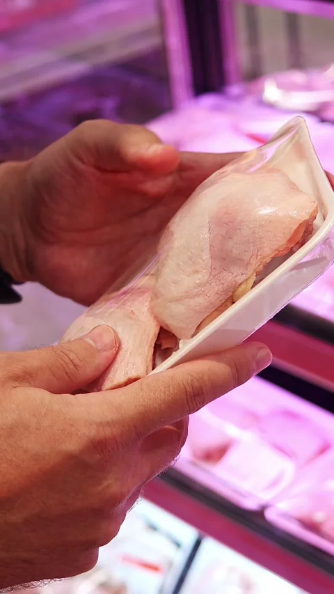Man holding packaged chicken thighs in supermarket Stock Footage 331470824