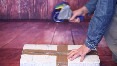 Man holding packing machine and sealing cardboard box with duct tape Stock Footage 149066462
