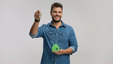 Man holding a pair of keys and a model house Stock Footage 77342439