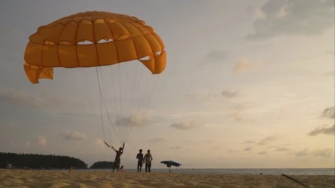 A man is holding a parachute downwind on the beach. Timelapse. Stock Footage 89639461