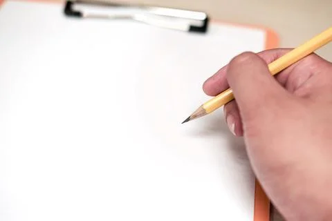 A man holding a pencil to write something on a blank white paper Stock Photos
