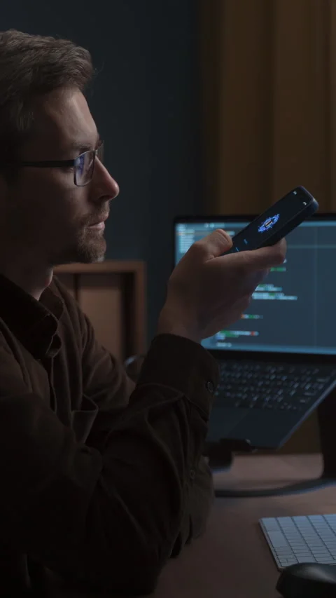 Man holding phone and using AI Voice Assistant App on Smartphone and pc. Stock Footage 341681525