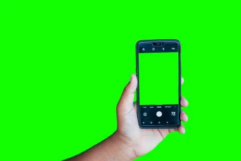 Man holding phone with camera interface against the green screen background Stock Photos