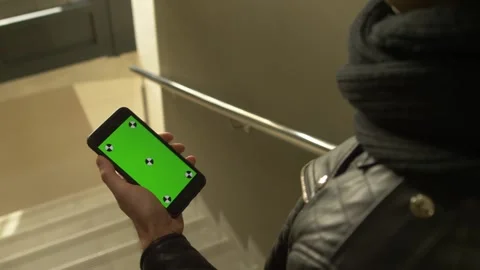 Man holding phone in one hand with green screen Stock Footage 210757706