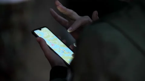 Man is holding a phone with an open application of a map of the area. Video stock 164456802