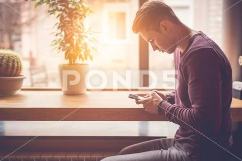 The man holding a phone at the restaurant table Stock Photos