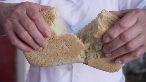 A man is holding a piece of bread in his hands Video stock 317455734