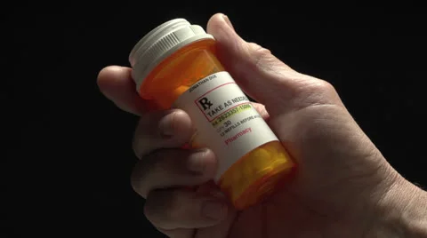 Man holding pill bottle Stock Footage 24706436