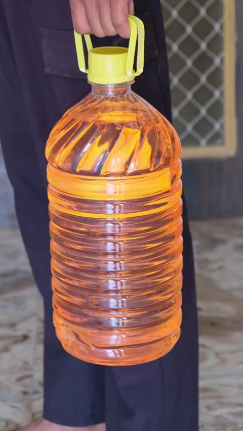 Man holding a plastic bottle filled with petrol or orange liquid Stock-Footage 330738562