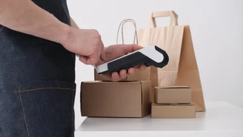 Man holding POS payment terminal printing out receipt with shopping bags and Stock Footage 265803445