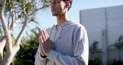 Man holding prayer pose, praying in yard while camera pulling back showing Stock Footage 339679170