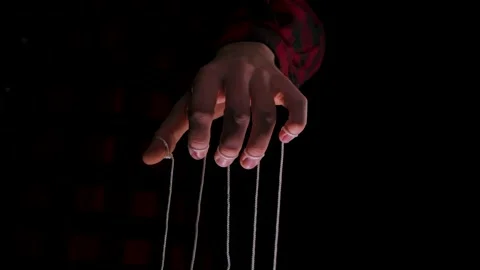 Man holding a puppet string. Close up human hand controls a puppet with fingers Stock Footage 146637568