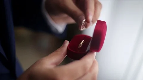 Man holding a red box with wedding rings Stock Footage 73240696