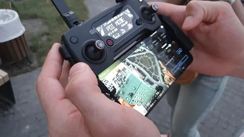 A man holding a remote control drone with a smartphone. 스톡 동영상 125876250