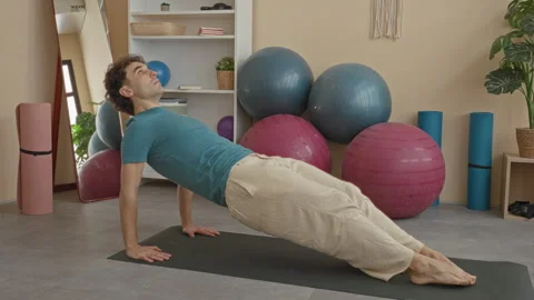 Man holding reverse plank with hands on mat and feet extended on yoga mat i.. 스톡 동영상 337435774