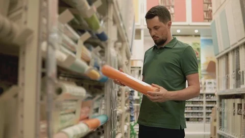 Man holding a roll of wallpaper. Stock Footage 91445983