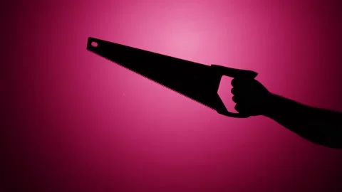 Man holding saw close-up, shadow silhouette of hand with sharp tool on pink neon Stock Footage 170586703