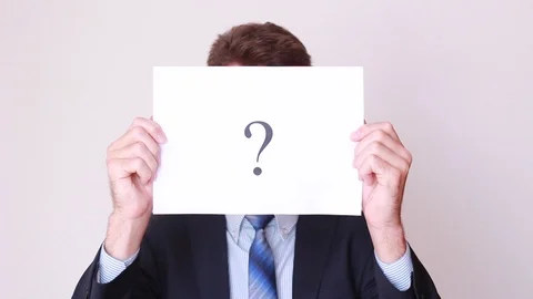 Man holding sheet with Question mark in front of his face Stock Footage 94651896
