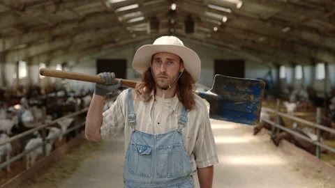 Man holding shovel on shoulder while walking at goat farm Stock Footage 157577545