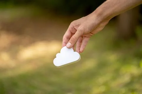 Man holding a simple white cloud symbol in hand, cloud computing and storag.. Stock Photos
