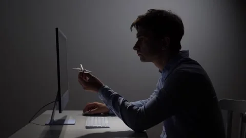 Man holding a small airplane model while sitting at his office desk Stock Footage 342671964
