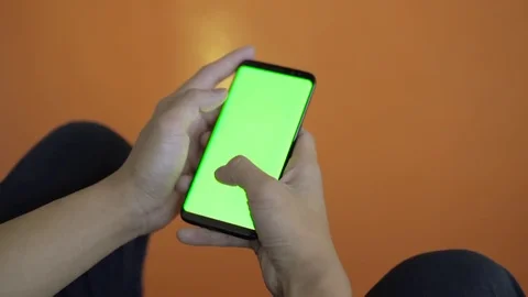 Man holding smart phone with both hands. Browsing and reading something Stockbeeldmateriaal 80555166