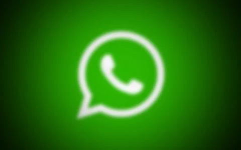 Man is holding smart phone in front of the whatsapp logo Stock Photos