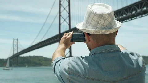 Man holding smartphone and captures the view on it, steadycam shot 스톡 동영상 76986933