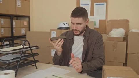 Man holding smartphone and touching shipping papers with hand at packing de.. Stock Footage 337362703