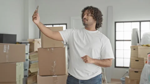 Man holding smartphone at arm's length for selfie in building with stacked .. Stock Footage 337404347