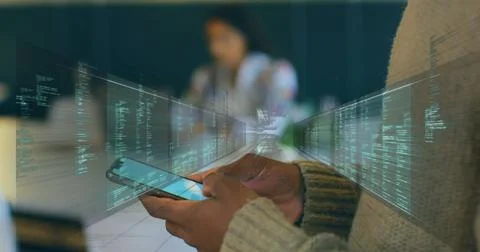 Man holding smartphone with code streaming across frame at office, blurred woman Stock-Fotos