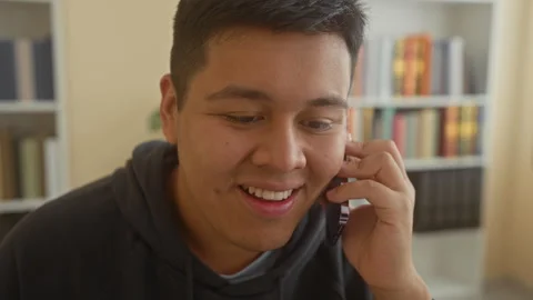 Man holding smartphone to ear and smiling toward monitor in an office build.. Video stock 337354229